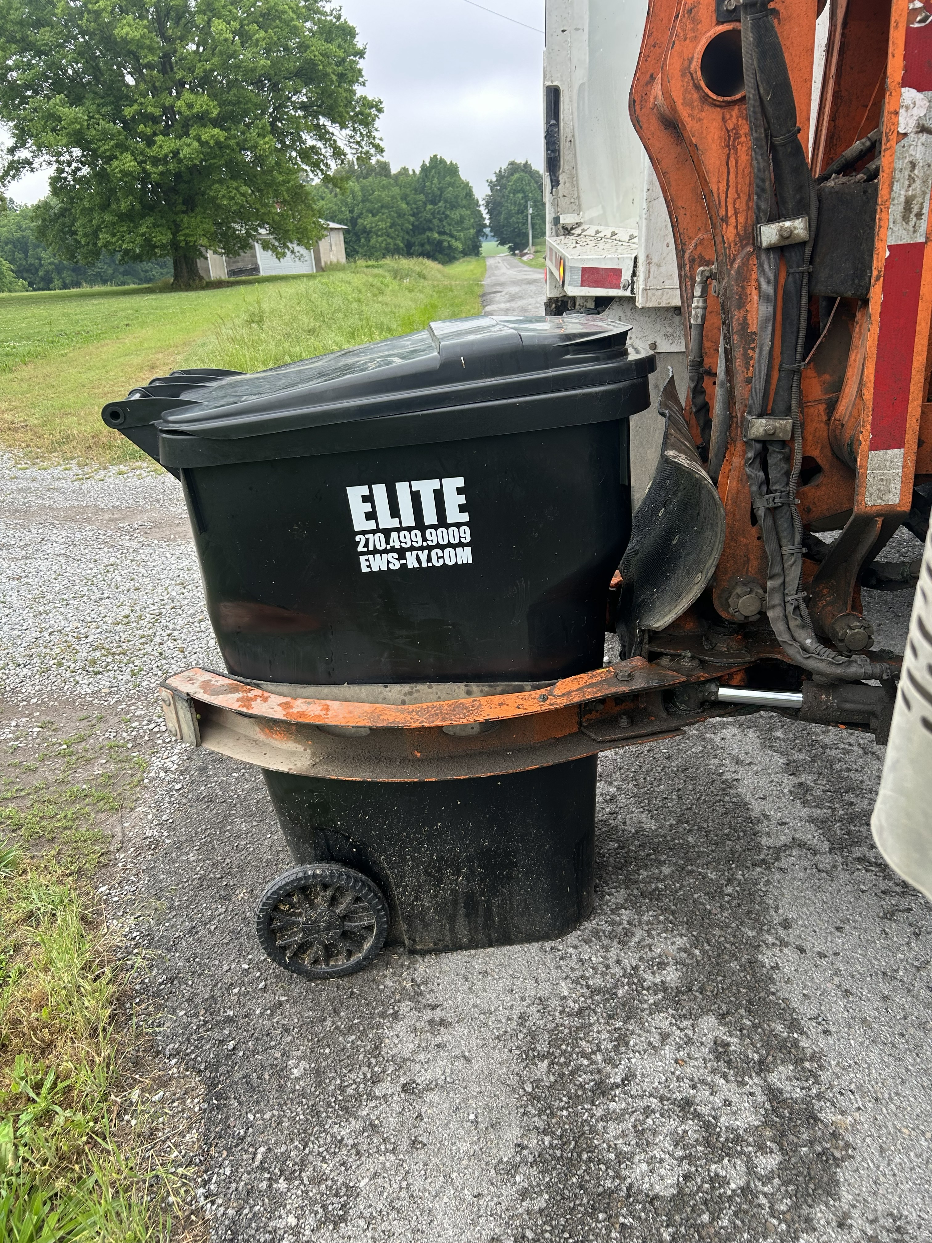 Elite Waste Services branded trash carts positioned in a residential neighborhood in Kentucky